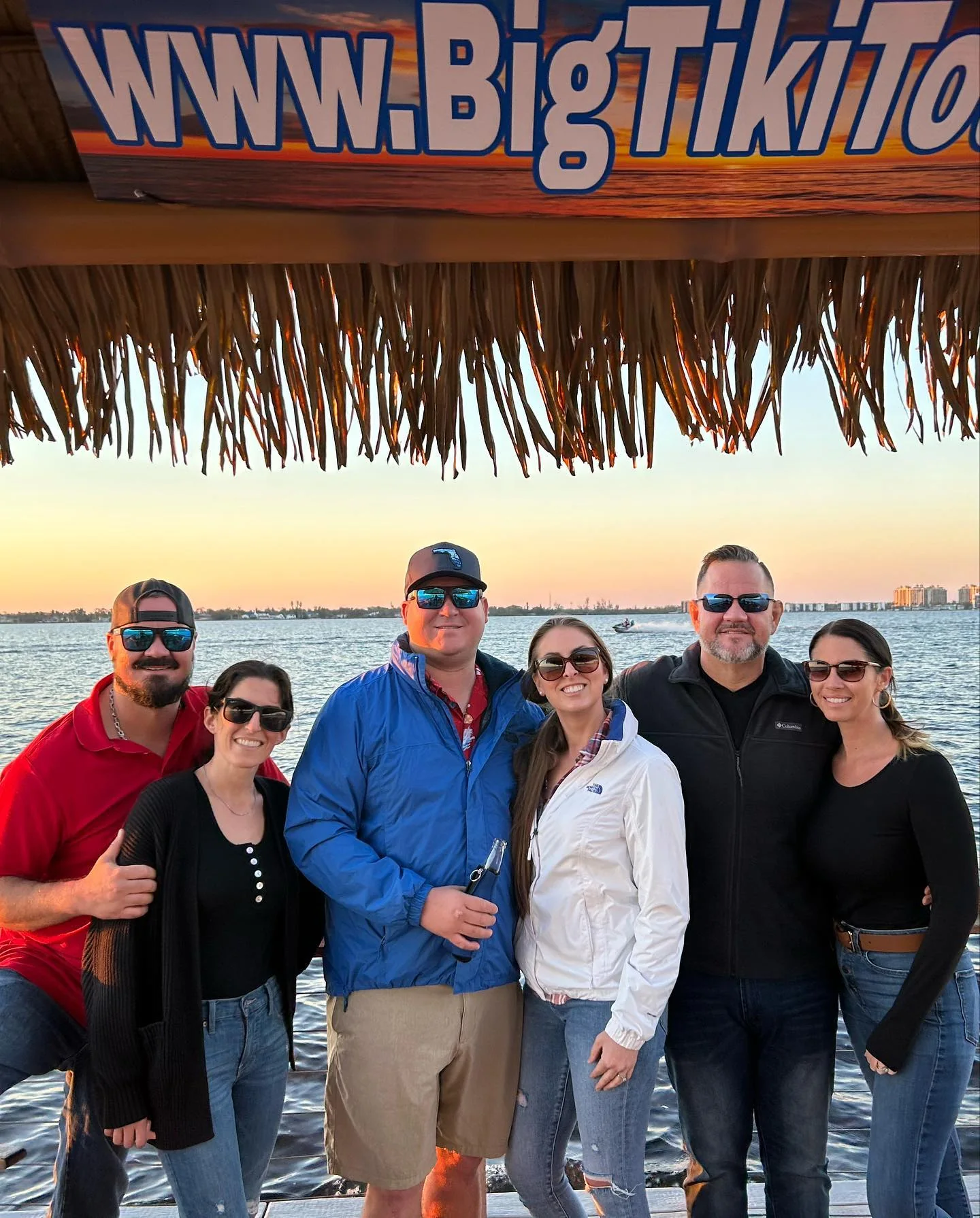 Group of guests together aboard Big Tiki Tours at sunset