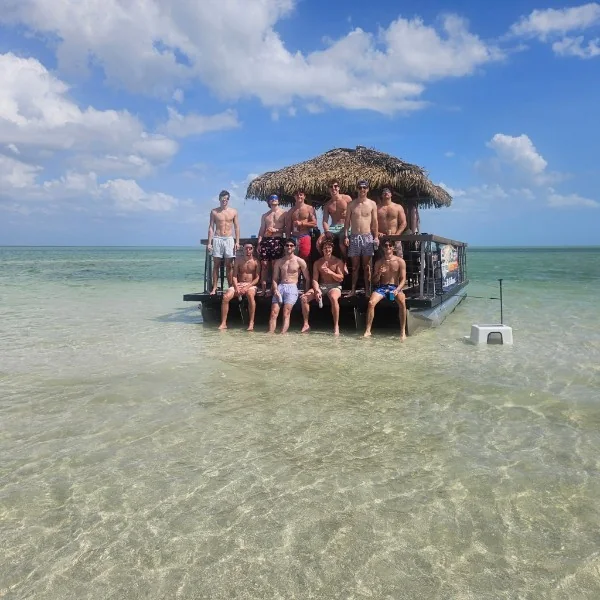 Friends gathered beside a Big Tiki Tours boat at a Southwest Florida sandbar