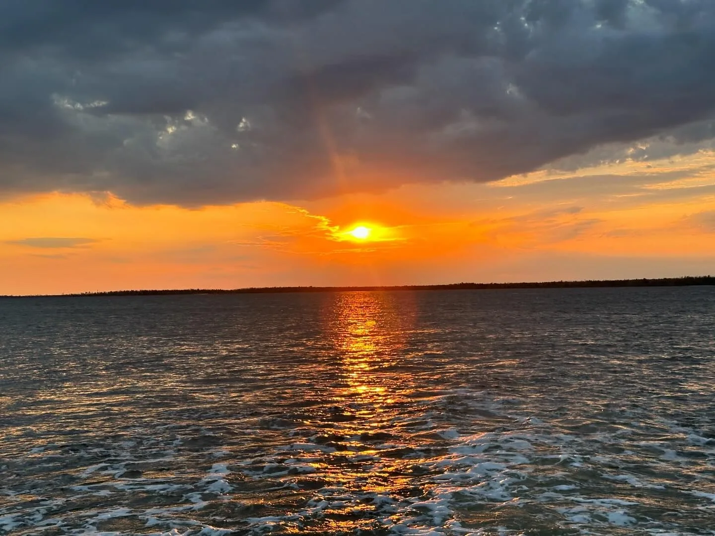 Orange sunset reflecting across Southwest Florida water during a Big Tiki cruise