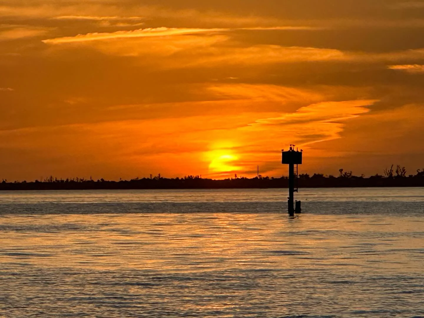Orange Southwest Florida sunset beside a channel marker