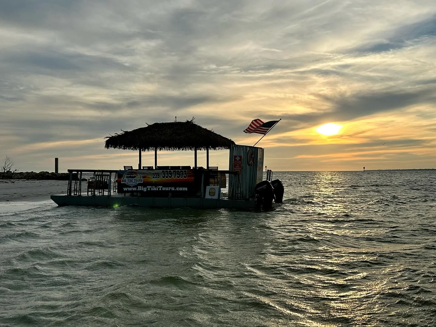 Tiki boat silhouetted against a Southwest Florida sunset