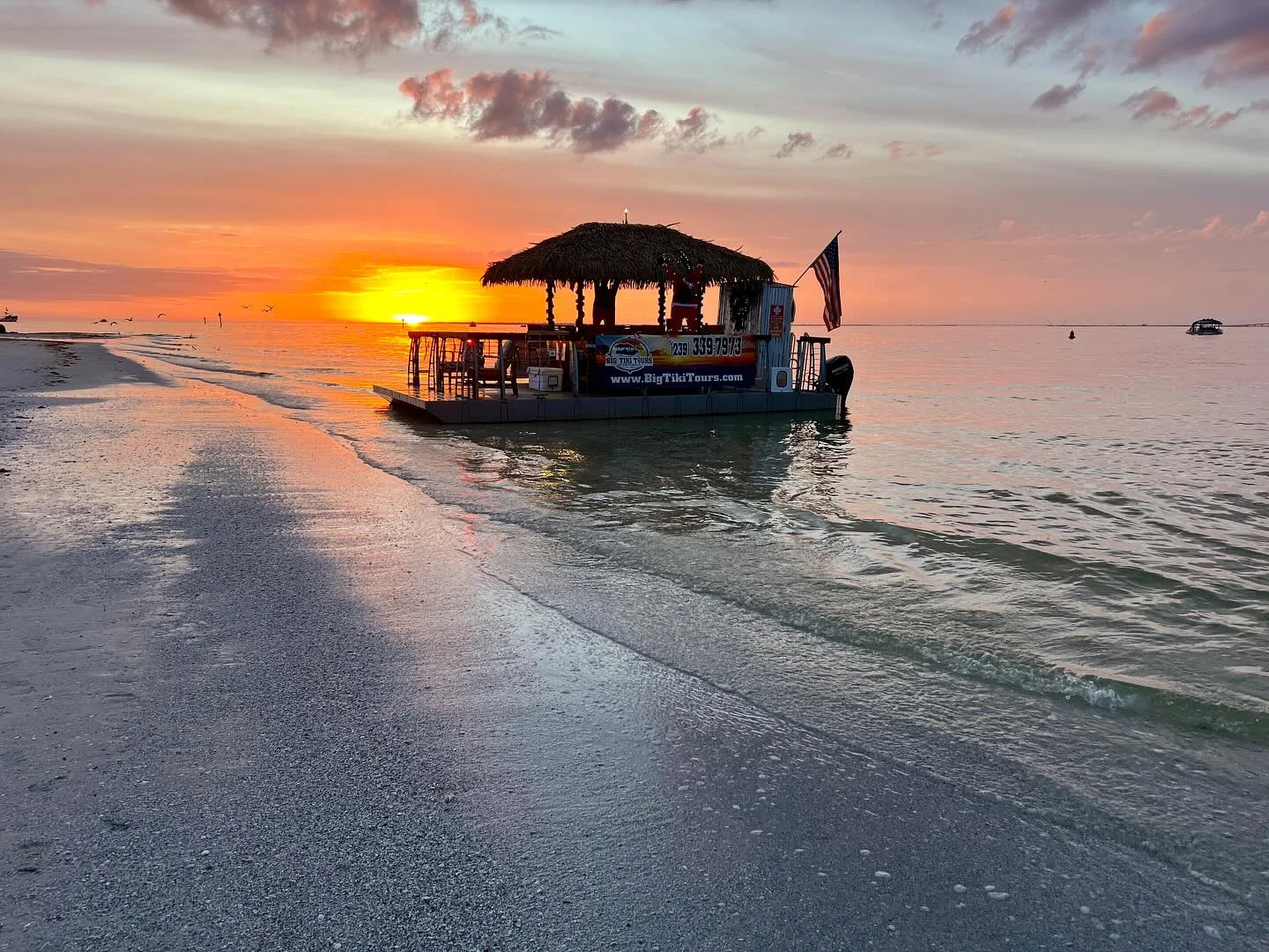 Big Tiki Tours boat near shore at a Southwest Florida sunset